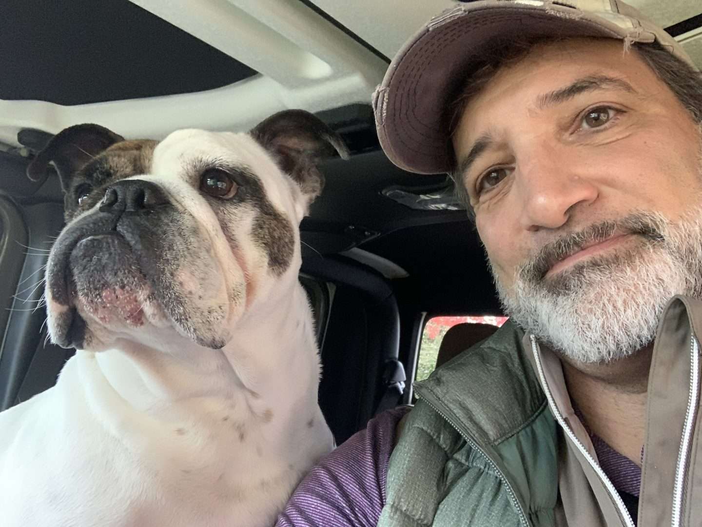A man taking a photo with his bulldog